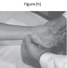 A person holding another persons hand while lying in bed.