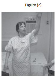 A woman in hospital gown holding up her arm.
